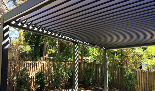 Sunair pergola with custom adjustable louvers partially tilted to let in sunlight while maintaining shade and comfort, showcasing versatile outdoor living design by Awnings by Bigley and Hogshire.