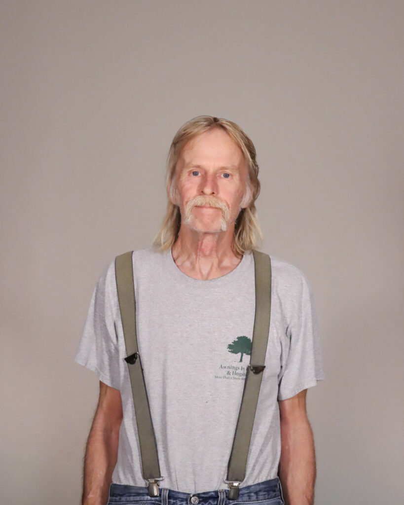 Chris Coen, the service manager for Awnings by Bigley & Hogshire stands proud to serve the company, wearing a smile and vintage Awnings by Bigley & Hogshire merch.