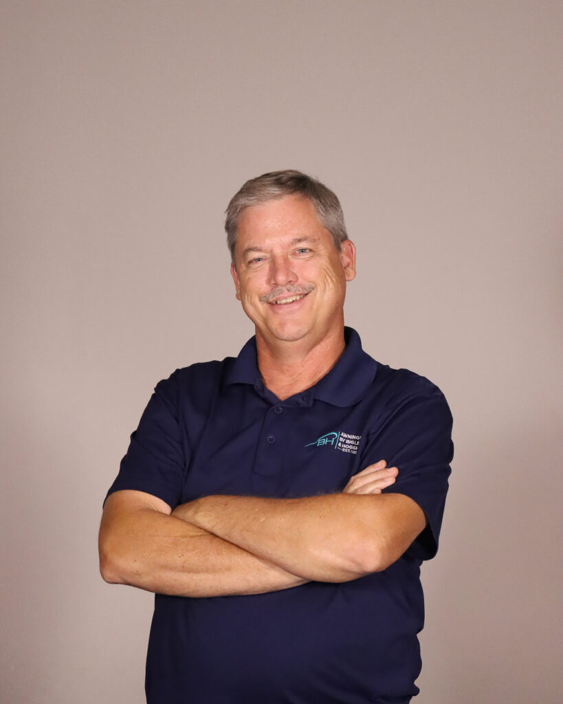 Edward Brandt, the sales manager for Awnings by Bigley & Hogshire stands proud to serve the company with his arms crossed and a beaming smile.